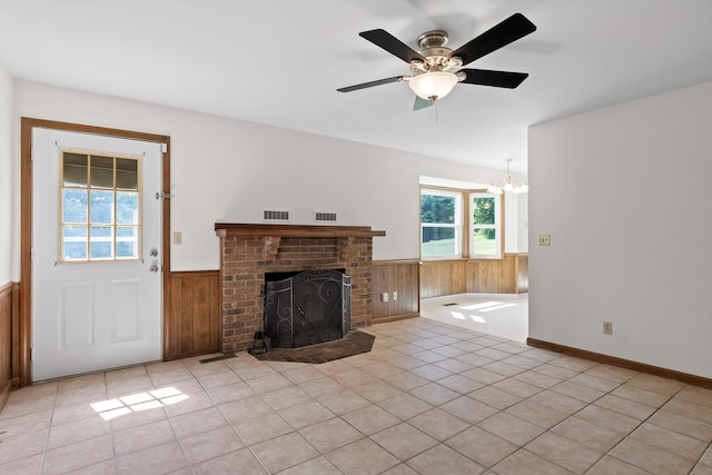 4920 Pine Cir, Ooltewah, TN 37363 - unfurnished living room featuring a wainscoted wall, a brick fireplace, a chandelier, wooden walls, and a ceiling fan