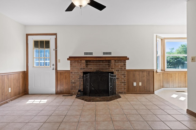 4920 Pine Cir, Ooltewah, TN 37363 - unfurnished living room with wainscoting, wooden walls, light tile patterned floors, a ceiling fan, and a brick fireplace