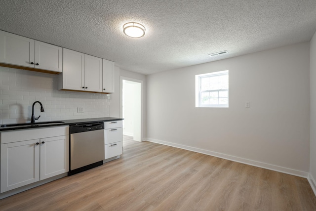 103 Laurel Dr, Chattanooga, TN 37415 - kitchen featuring dishwasher, dark countertops, light wood-style floors, backsplash, and white cabinets