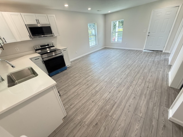 220 Given St, Summerville, GA 30747 - kitchen with stainless steel appliances, light wood-type flooring, light countertops, white cabinets, and recessed lighting
