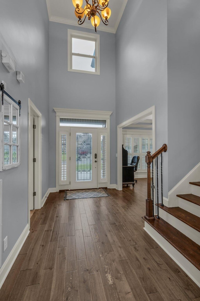7459 Red Poppy Dr, Ooltewah, TN 37363 - entrance foyer featuring a chandelier, a towering ceiling, dark wood-type flooring, stairway, and ornamental molding