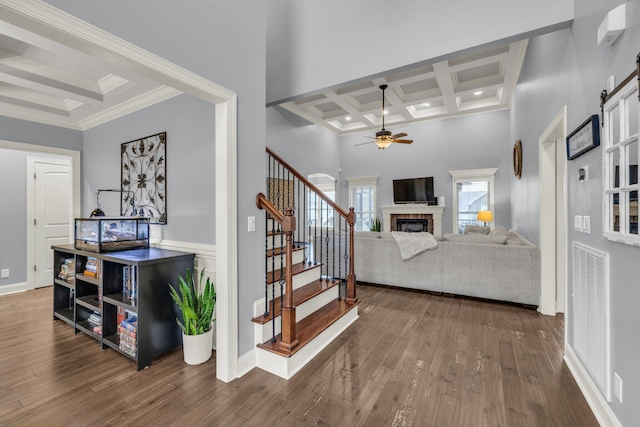 7459 Red Poppy Dr, Ooltewah, TN 37363 - stairs featuring coffered ceiling, ceiling fan, a fireplace, beam ceiling, and wood finished floors