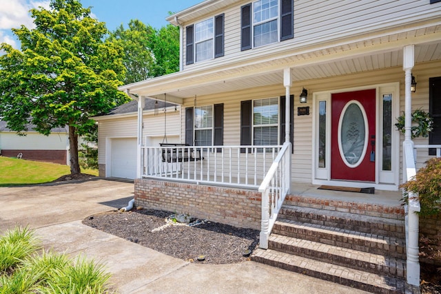 8616 River Cove Dr, Harrison, TN 37341 - view of exterior entry featuring covered porch, concrete driveway, and a garage
