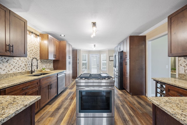 8616 River Cove Dr, Harrison, TN 37341 - kitchen featuring appliances with stainless steel finishes, dark wood finished floors, decorative backsplash, light stone counters, and crown molding