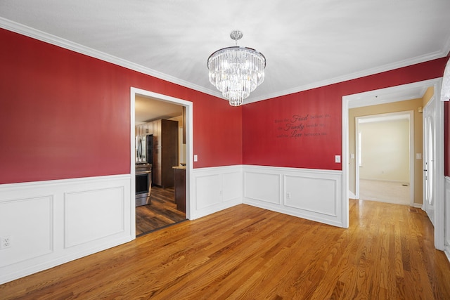 8616 River Cove Dr, Harrison, TN 37341 - unfurnished dining area featuring a chandelier, wood finished floors, ornamental molding, and wainscoting