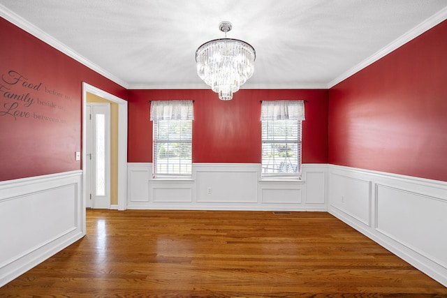 8616 River Cove Dr, Harrison, TN 37341 - unfurnished dining area featuring healthy amount of natural light, a chandelier, a wainscoted wall, wood finished floors, and crown molding