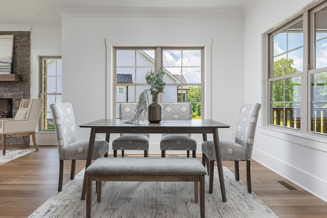 234 Goose Creek Cir, Soddy Daisy, TN 37379 - dining space with crown molding, healthy amount of natural light, wood finished floors, and a stone fireplace