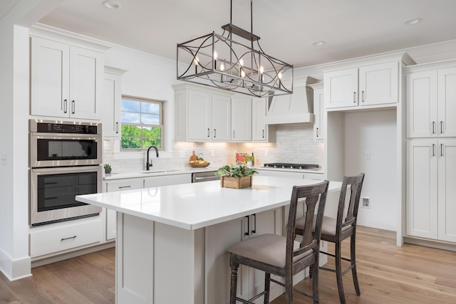 234 Goose Creek Cir, Soddy Daisy, TN 37379 - kitchen featuring stainless steel appliances, custom exhaust hood, a center island, white cabinets, and recessed lighting