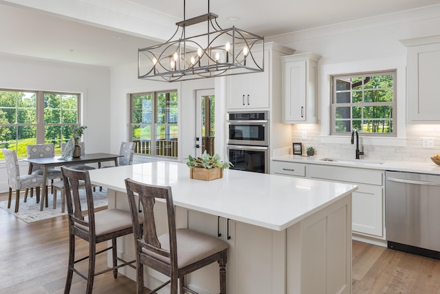 234 Goose Creek Cir, Soddy Daisy, TN 37379 - kitchen featuring stainless steel appliances, light wood-style flooring, tasteful backsplash, light countertops, and a center island