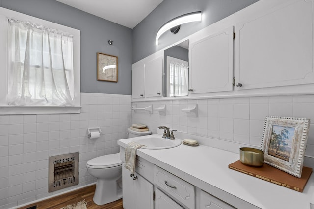620 Lullwater Rd, Chattanooga, TN 37405 - bathroom with heating unit, vanity, wood finished floors, tile walls, and a wainscoted wall