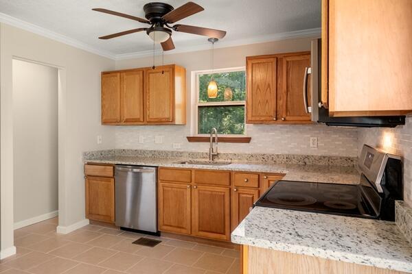 3224 Through St, Chattanooga, TN 37411 - kitchen with stainless steel appliances, ceiling fan, backsplash, ornamental molding, and light tile patterned flooring