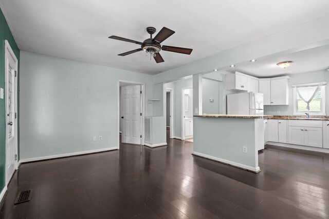 702 Runyan Dr, Chattanooga, TN 37405 - kitchen with freestanding refrigerator, ceiling fan, white cabinets, dark wood-type flooring, and light stone countertops