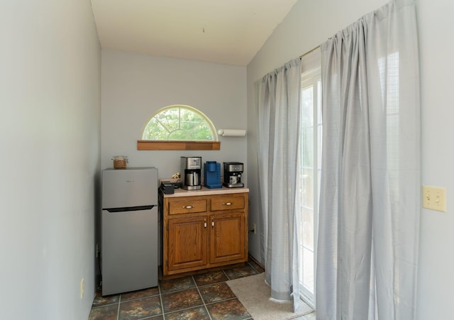 515 Choctaw Trl, Chattanooga, TN 37405 - kitchen with freestanding refrigerator, brown cabinetry, dark stone finish flooring, and light countertops