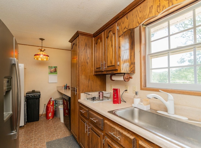 515 Choctaw Trl, Chattanooga, TN 37405 - kitchen featuring stainless steel refrigerator with ice dispenser, brown cabinets, light countertops, hanging light fixtures, and a textured ceiling