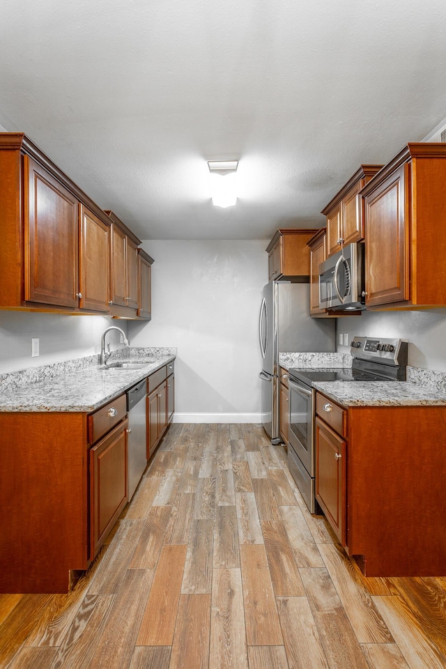 900 Mountain Creek Rd Unit P224, Chattanooga, TN 37405 - kitchen with appliances with stainless steel finishes, light wood-style flooring, light stone counters, and brown cabinetry