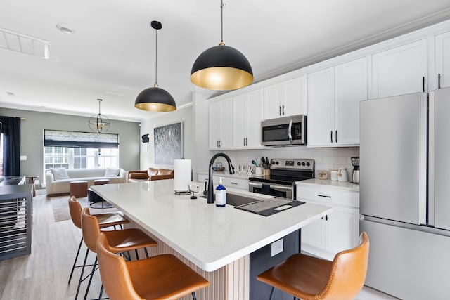 1476 Chatt City Way, Chattanooga, TN 37408 - kitchen with stainless steel appliances, a breakfast bar area, open floor plan, white cabinets, and backsplash