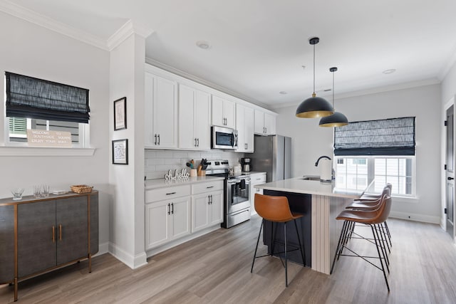 1476 Chatt City Way, Chattanooga, TN 37408 - kitchen with stainless steel appliances, light wood-style floors, ornamental molding, an island with sink, and white cabinetry