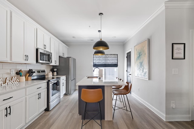 1476 Chatt City Way, Chattanooga, TN 37408 - kitchen featuring stainless steel appliances, an island with sink, light wood-type flooring, a kitchen breakfast bar, and white cabinetry
