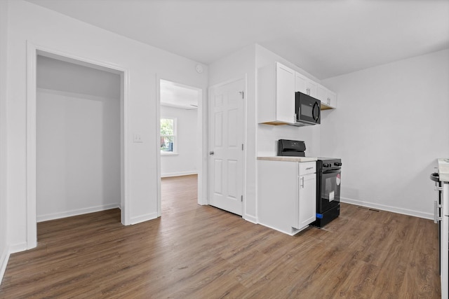 3002 Peggy Ln, Chattanooga, TN 37404 - kitchen with black appliances, white cabinetry, light countertops, and dark wood-style floors