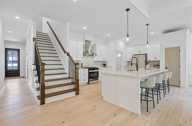 8340 Snowdrop Way, Ooltewah, TN 37363 - kitchen featuring gas stove, wall chimney exhaust hood, backsplash, a breakfast bar, and white cabinets