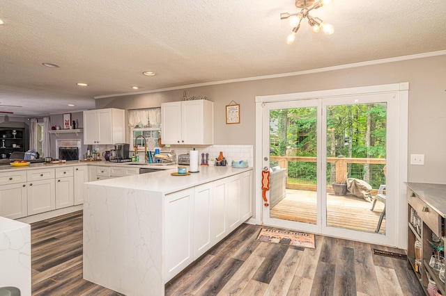 848 Skyline Park Dr, Signal Mountain, TN 37377 - kitchen featuring a peninsula, a textured ceiling, white cabinetry, light countertops, and ornamental molding