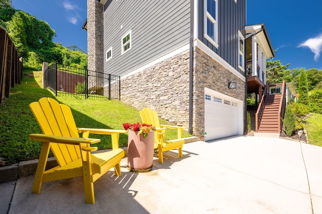 834 Dartmouth St, Chattanooga, TN 37405 - view of property exterior featuring stone siding, an attached garage, board and batten siding, stairway, and driveway