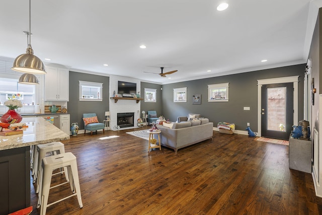 834 Dartmouth St, Chattanooga, TN 37405 - living room featuring ceiling fan, ornamental molding, a large fireplace, dark wood-type flooring, and recessed lighting