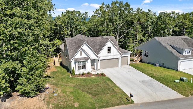 596 Nature Trl, Soddy Daisy, TN 37379 - view of front of home featuring concrete driveway, a front lawn, a garage, and roof with shingles