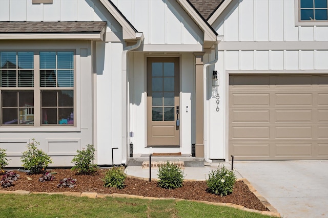 596 Nature Trl, Soddy Daisy, TN 37379 - view of exterior entry with board and batten siding, roof with shingles, a garage, and concrete driveway