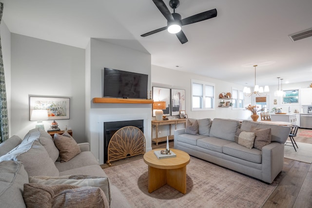 8520 Kensley Ln, Hixson, TN 37343 - living area featuring wood finished floors, a fireplace, healthy amount of natural light, a chandelier, and vaulted ceiling