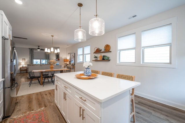 8520 Kensley Ln, Hixson, TN 37343 - kitchen featuring freestanding refrigerator, light wood-style flooring, white cabinetry, a center island, and light countertops