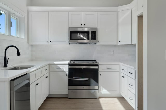 1310 Top St, Chattanooga, TN 37408 - kitchen with stainless steel appliances, tasteful backsplash, light countertops, and white cabinets