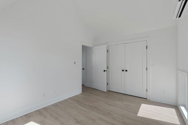 1310 Top St, Chattanooga, TN 37408 - unfurnished bedroom featuring light wood finished floors, an AC wall unit, a closet, and lofted ceiling