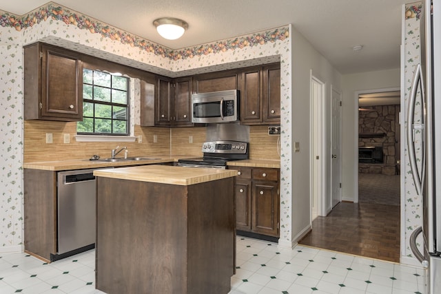 6515 Lake Shadows Cir, Hixson, TN 37343 - kitchen featuring butcher block countertops, dark brown cabinets, stainless steel appliances, decorative backsplash, and wallpapered walls