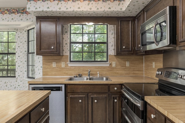 6515 Lake Shadows Cir, Hixson, TN 37343 - kitchen with appliances with stainless steel finishes, wooden counters, dark brown cabinets, decorative backsplash, and wallpapered walls