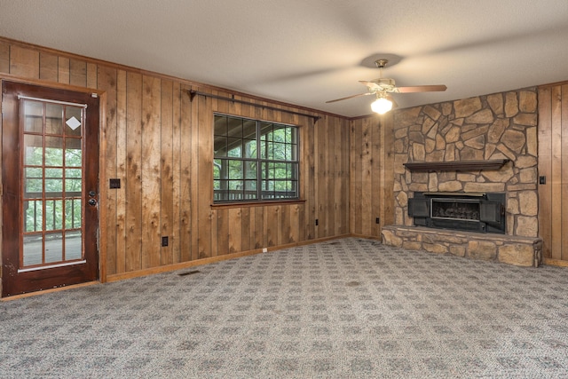 6515 Lake Shadows Cir, Hixson, TN 37343 - unfurnished living room with carpet, ceiling fan, wood walls, and a stone fireplace