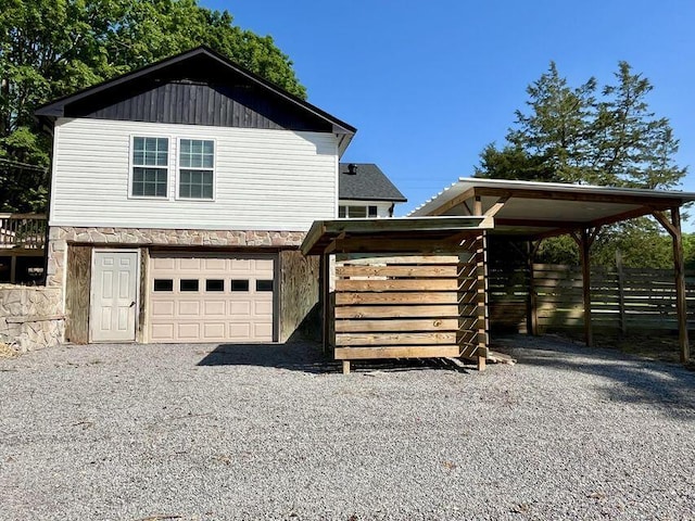 6248 Old Dunlap Rd, Whitwell, TN 37397 - view of front of house with stone siding, an attached garage, gravel driveway, and a carport