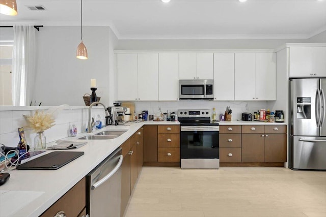 1493 Sinclair Ave, Chattanooga, TN 37408 - kitchen with appliances with stainless steel finishes, decorative backsplash, ornamental molding, light countertops, and light wood-type flooring
