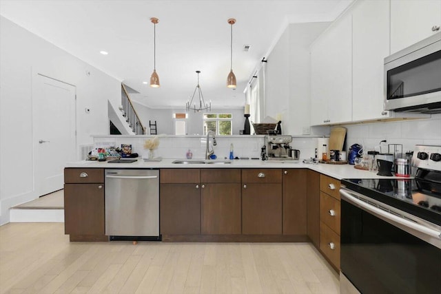 1493 Sinclair Ave, Chattanooga, TN 37408 - kitchen with stainless steel appliances, light countertops, tasteful backsplash, a peninsula, and a chandelier