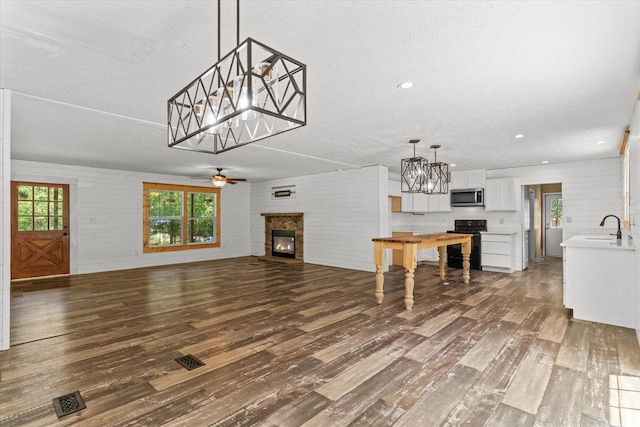 1483 Resaca Lafayette Rd NW, Resaca, GA 30735 - unfurnished living room featuring a glass covered fireplace, dark wood-style floors, ceiling fan, a chandelier, and recessed lighting