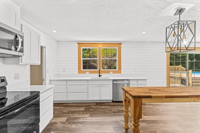 1483 Resaca Lafayette Rd NW, Resaca, GA 30735 - kitchen featuring appliances with stainless steel finishes, a textured ceiling, dark wood-style floors, white cabinets, and a chandelier