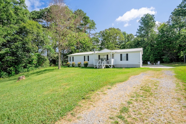 63 Applewood Ln, Chatsworth, GA 30705 - manufactured / mobile home with driveway, a front lawn, a metal roof, and view of wooded area