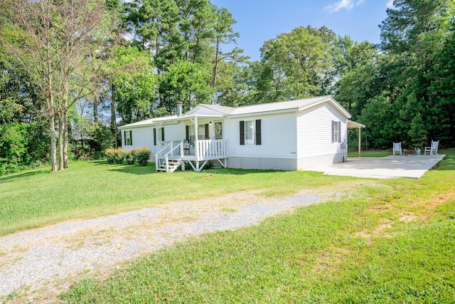 63 Applewood Ln, Chatsworth, GA 30705 - manufactured / mobile home featuring covered porch, driveway, a front yard, and a metal roof