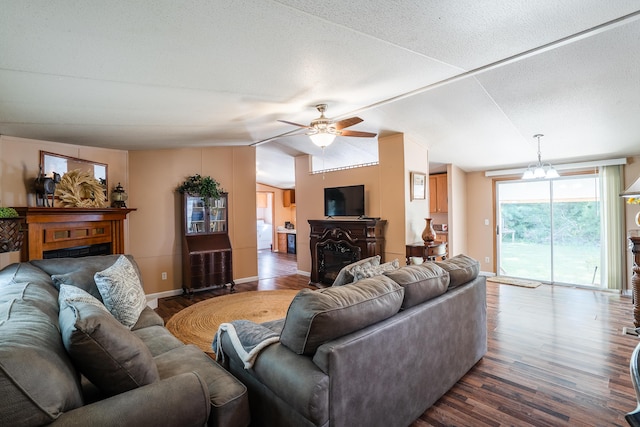 63 Applewood Ln, Chatsworth, GA 30705 - living room featuring a fireplace, dark wood-style flooring, ceiling fan, lofted ceiling, and a chandelier