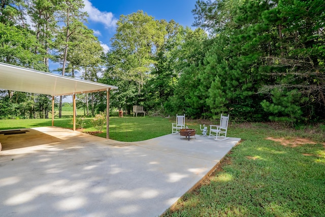 63 Applewood Ln, Chatsworth, GA 30705 - view of grassy yard featuring a fire pit, a patio area, view of scattered trees, and a carport