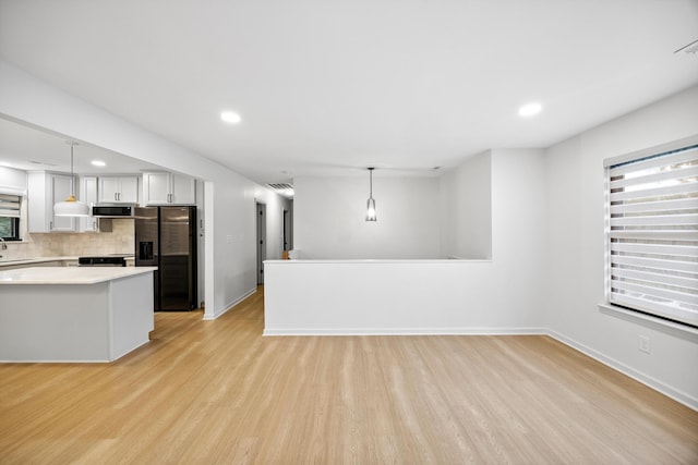 2427 Maplewood Dr, Chattanooga, TN 37421 - kitchen with refrigerator with ice dispenser, stainless steel microwave, light countertops, light wood finished floors, and backsplash