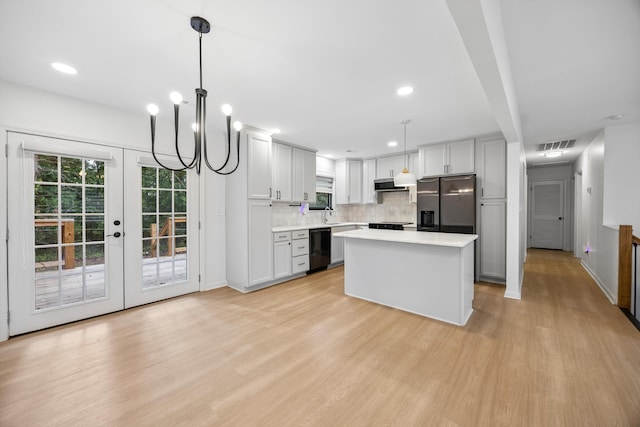 2427 Maplewood Dr, Chattanooga, TN 37421 - kitchen with light wood-style floors, refrigerator with ice dispenser, exhaust hood, decorative backsplash, and light countertops