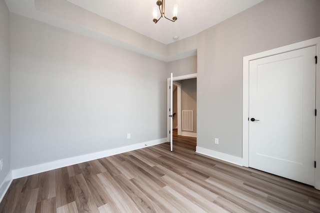 745 Burnside Pl, Chattanooga, TN 37408 - unfurnished bedroom featuring a chandelier and light wood-style floors