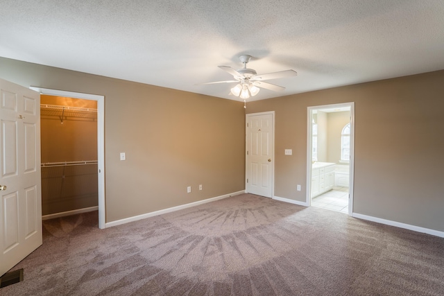 601 Black Oak Dr Unit 118, Dalton, GA 30721 - unfurnished bedroom featuring a spacious closet, carpet flooring, a textured ceiling, connected bathroom, and a ceiling fan