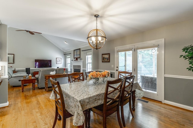 212 Cox Ln, Soddy Daisy, TN 37379 - dining area featuring a chandelier, light wood finished floors, a fireplace, lofted ceiling, and a ceiling fan